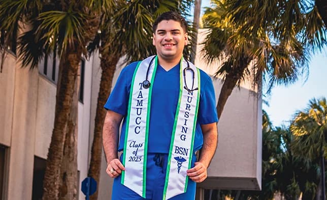 Young man smiling with his stole and stethoscope.