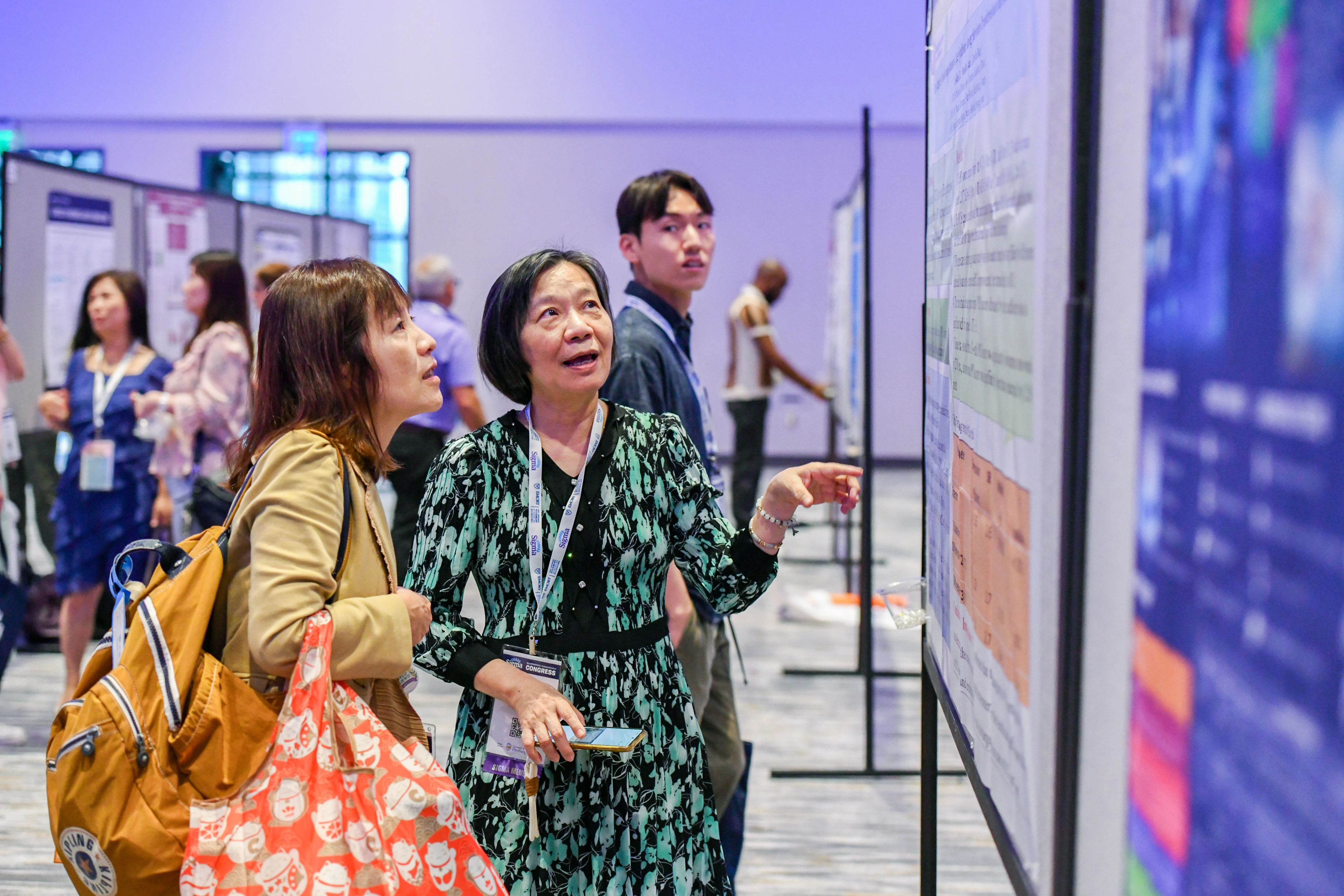 Two women look at a research board at a conference.
